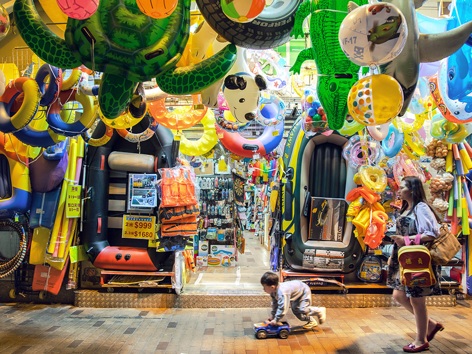 Boy plays with toy car on Fuk Wing Street in Sham Shui Po