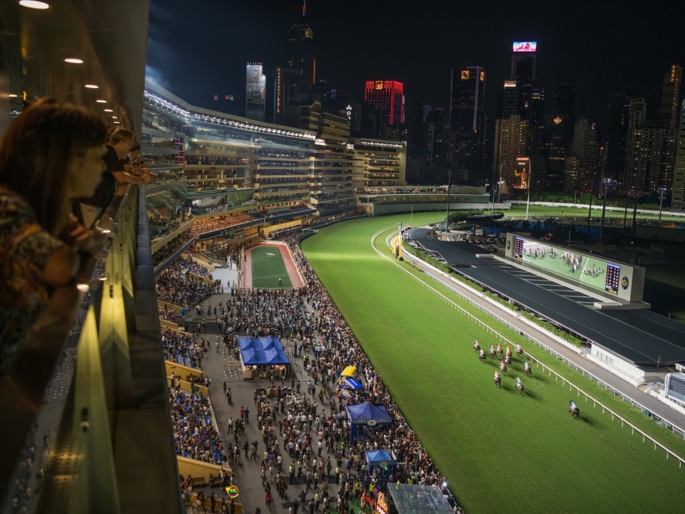 Spectators watching the horse races at Happy Valley Racecourse on Happy Wednesday nights.