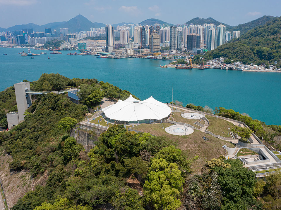 Aerial view of the Hong Kong Museum of the War of Resistance and Coastal Defence surrounded by green trees and blue waters.