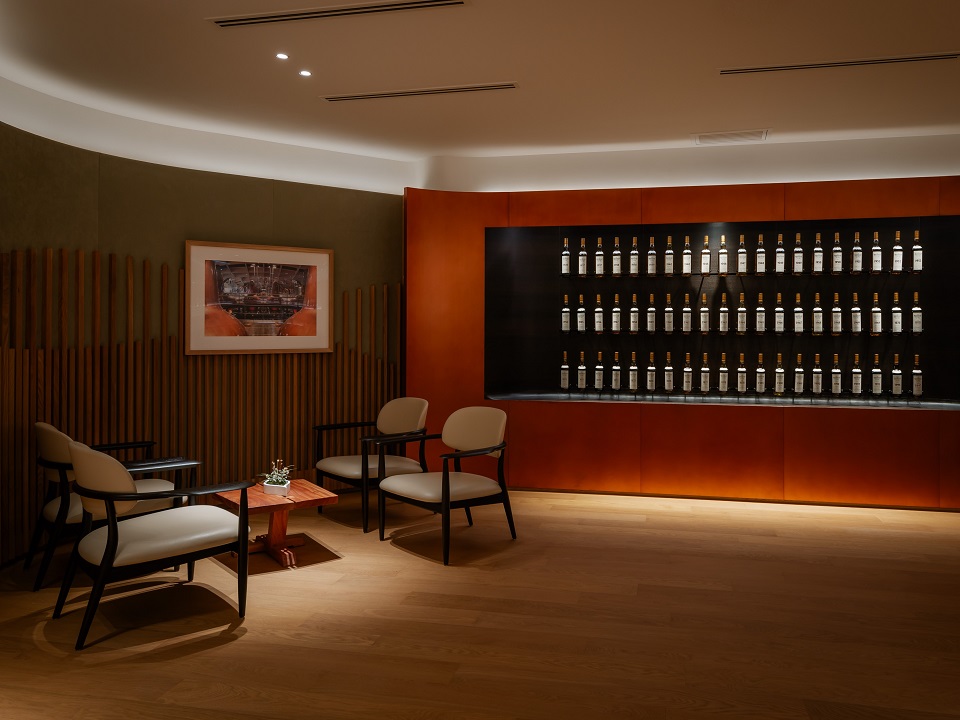 A dimmed room with a large collection of fine and rare whiskies on display at The Macallan House