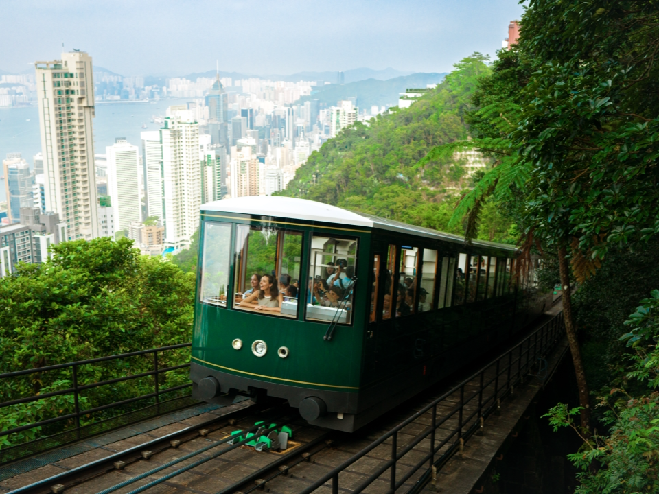 Tourists take in the Hong Kong city views as they ride the Peak Tram