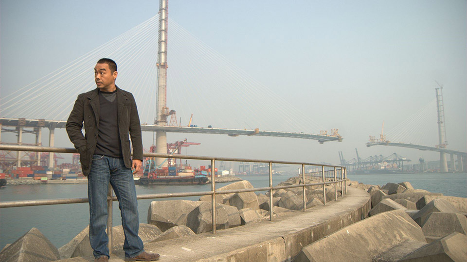 Inspector Leung from the movie ‘Overheard’ stands in front of Stonecutters bridge in Hong Kong.